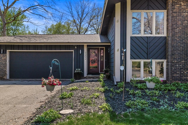 1302 Birch Dr, Hudson, WI 54016 - property entrance featuring board and batten siding, brick siding, an attached garage, and driveway