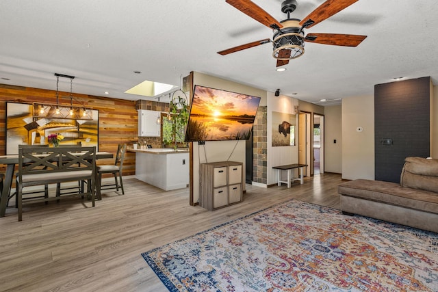 1302 Birch Dr, Hudson, WI 54016 - living area featuring a ceiling fan, light wood finished floors, a textured ceiling, and baseboards