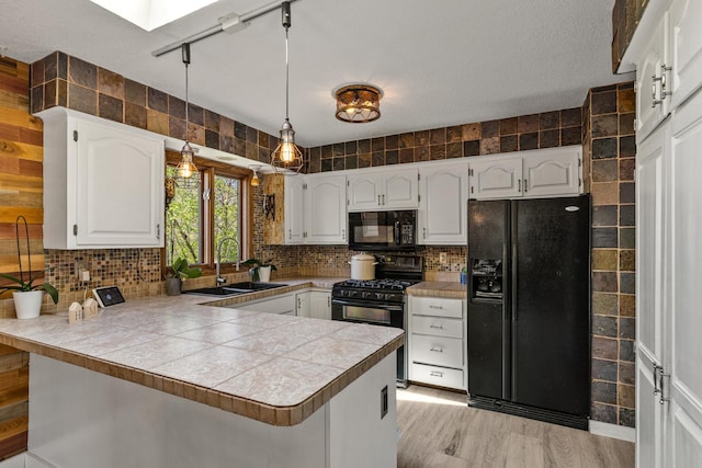 1302 Birch Dr, Hudson, WI 54016 - kitchen featuring black appliances, a sink, a peninsula, white cabinets, and decorative backsplash