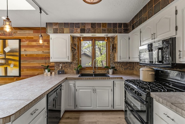 1302 Birch Dr, Hudson, WI 54016 - kitchen with black appliances, a sink, a peninsula, decorative backsplash, and a textured ceiling