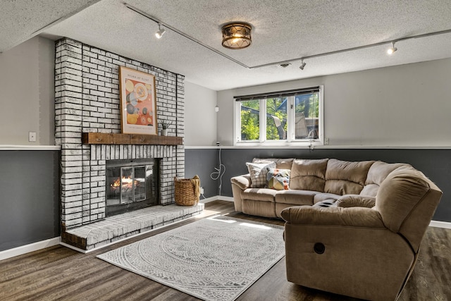 1302 Birch Dr, Hudson, WI 54016 - living room featuring rail lighting, wood finished floors, baseboards, and a textured ceiling