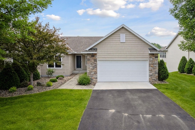 2117 14th St NE, Faribault, MN 55021 - view of front of house with asphalt driveway, a front lawn, roof with shingles, and stone siding