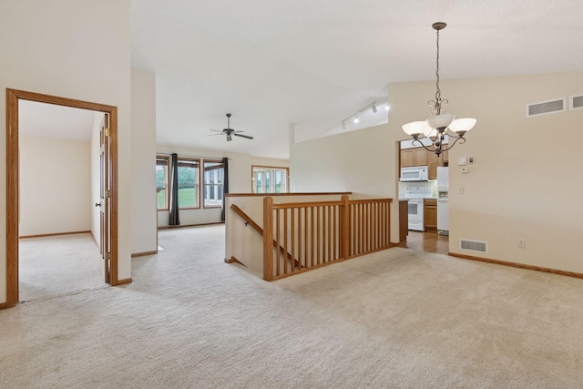 2117 14th St NE, Faribault, MN 55021 - unfurnished room featuring vaulted ceiling, light colored carpet, a chandelier, rail lighting, and a ceiling fan