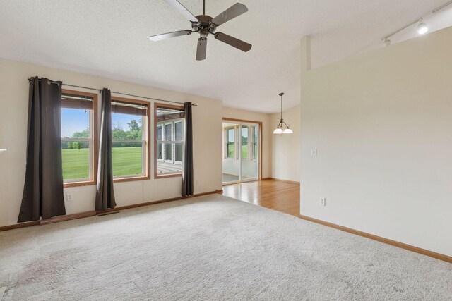 2117 14th St NE, Faribault, MN 55021 - carpeted spare room featuring ceiling fan, a chandelier, lofted ceiling, and track lighting