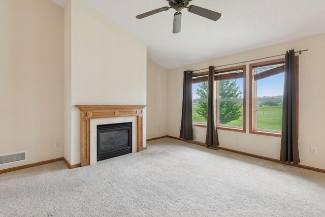 2117 14th St NE, Faribault, MN 55021 - unfurnished living room with lofted ceiling, carpet flooring, a glass covered fireplace, and a ceiling fan
