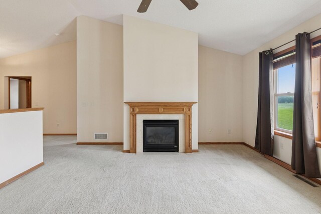 2117 14th St NE, Faribault, MN 55021 - unfurnished living room featuring vaulted ceiling, carpet flooring, a ceiling fan, and a glass covered fireplace