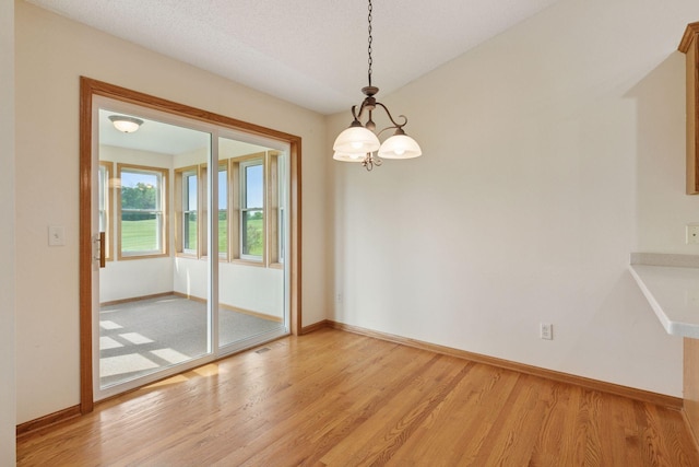 2117 14th St NE, Faribault, MN 55021 - empty room featuring light wood finished floors and a chandelier
