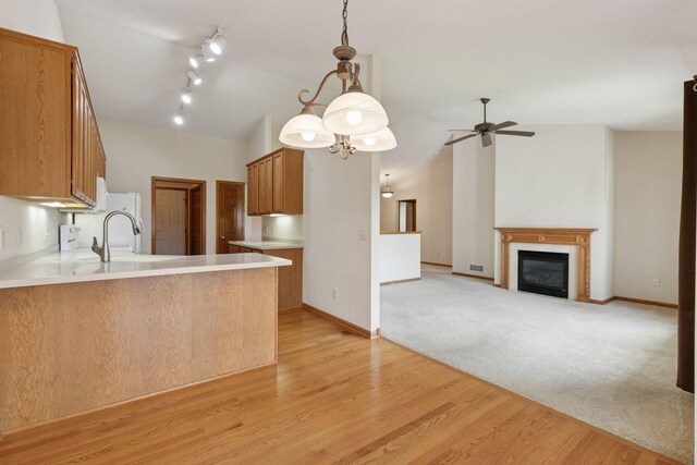 2117 14th St NE, Faribault, MN 55021 - kitchen featuring vaulted ceiling, a peninsula, ceiling fan, light countertops, and brown cabinetry