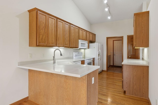 2117 14th St NE, Faribault, MN 55021 - kitchen with white appliances, a peninsula, light wood finished floors, light countertops, and brown cabinets