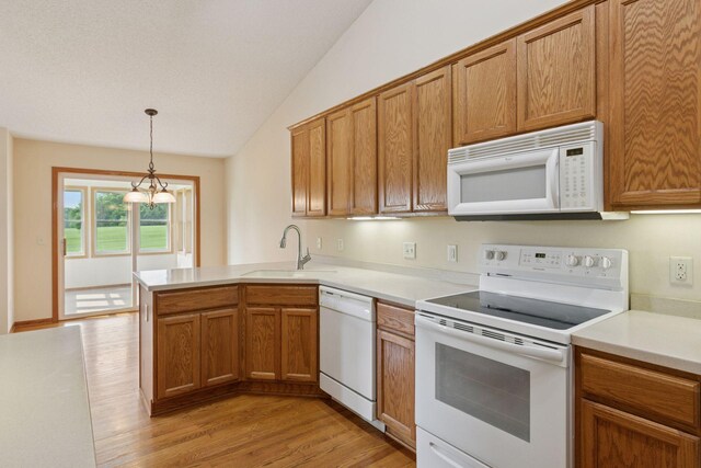 2117 14th St NE, Faribault, MN 55021 - kitchen featuring white appliances, a peninsula, light wood-type flooring, lofted ceiling, and brown cabinets