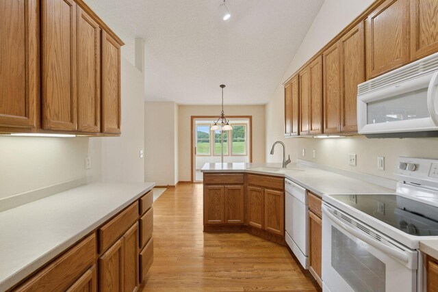 2117 14th St NE, Faribault, MN 55021 - kitchen featuring white appliances, light wood-type flooring, a peninsula, light countertops, and vaulted ceiling