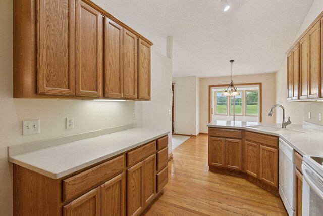 2117 14th St NE, Faribault, MN 55021 - kitchen with white dishwasher, light wood-type flooring, brown cabinetry, decorative light fixtures, and light countertops
