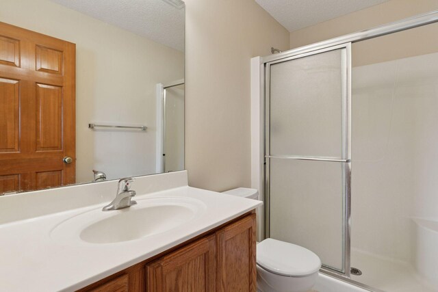 2117 14th St NE, Faribault, MN 55021 - bathroom with a shower with shower door, vanity, and a textured ceiling