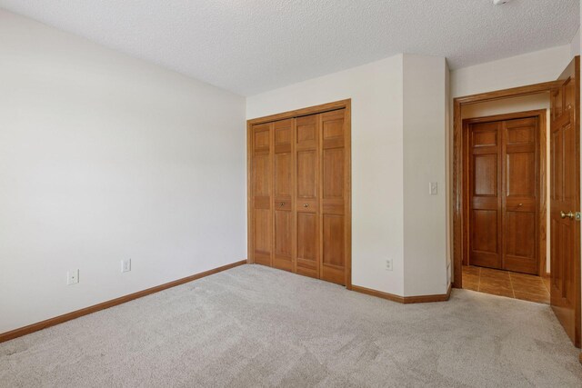 2117 14th St NE, Faribault, MN 55021 - unfurnished bedroom with carpet, a closet, and a textured ceiling
