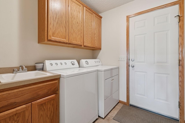 2117 14th St NE, Faribault, MN 55021 - laundry area with washing machine and clothes dryer, cabinet space, a textured ceiling, and light tile patterned flooring