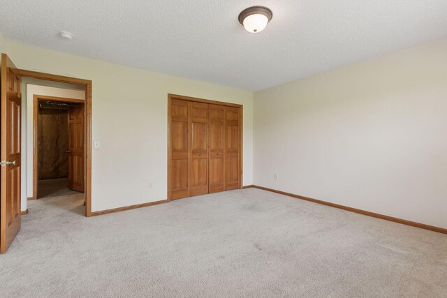 2117 14th St NE, Faribault, MN 55021 - unfurnished bedroom with a closet, light carpet, and a textured ceiling