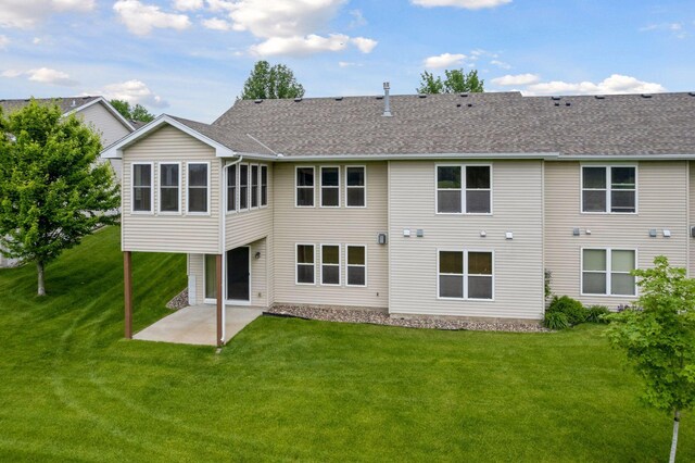 2117 14th St NE, Faribault, MN 55021 - back of property with a patio, a lawn, and a shingled roof