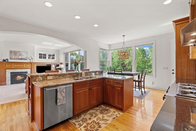 5761 Sunnybrook Ln, Minnetrista, MN 55364 - kitchen with stainless steel dishwasher, a sink, a fireplace, light wood-style flooring, and brown cabinets