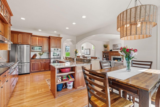 5761 Sunnybrook Ln, Minnetrista, MN 55364 - kitchen featuring appliances with stainless steel finishes, open shelves, arched walkways, recessed lighting, and light wood finished floors