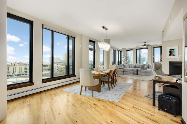 1240 2nd St Unit 701, Minneapolis, MN 55415 - dining room with baseboard heating, wood finished floors, a chandelier, and a ceiling fan