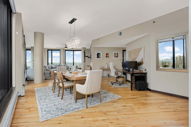 1240 2nd St Unit 701, Minneapolis, MN 55415 - dining area featuring baseboard heating, a chandelier, light wood finished floors, and baseboards