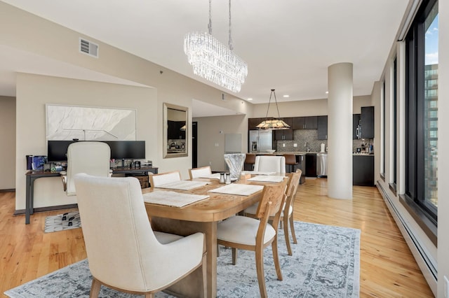 1240 2nd St Unit 701, Minneapolis, MN 55415 - dining space featuring a baseboard radiator, light wood-style floors, a chandelier, and recessed lighting