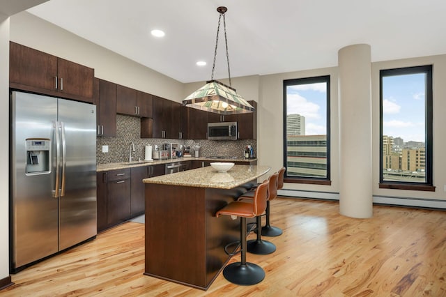 1240 2nd St Unit 701, Minneapolis, MN 55415 - kitchen with stainless steel appliances, a sink, dark brown cabinetry, light wood finished floors, and recessed lighting
