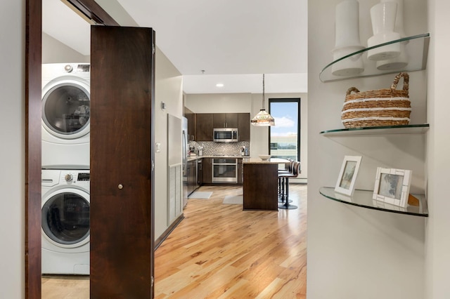 1240 2nd St Unit 701, Minneapolis, MN 55415 - washroom with estacked washer and dryer, light wood-style flooring, and recessed lighting