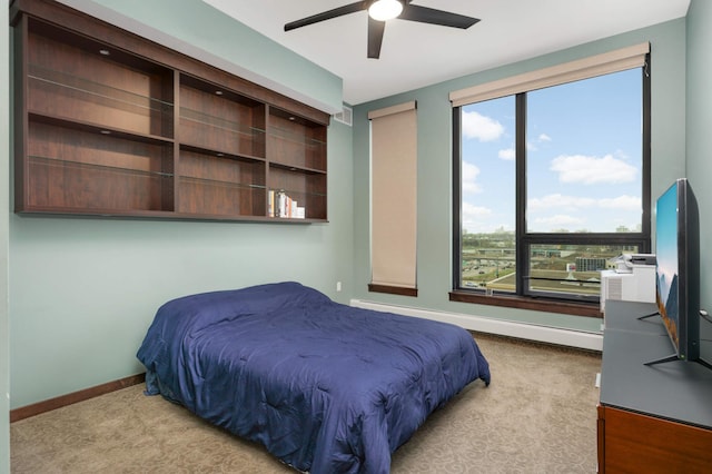 1240 2nd St Unit 701, Minneapolis, MN 55415 - bedroom featuring baseboard heating, light carpet, baseboards, and ceiling fan