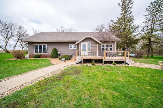 back of property featuring roof with shingles, a yard, and a deck