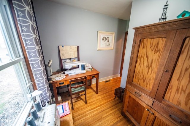office featuring baseboards, visible vents, and light wood-style floors