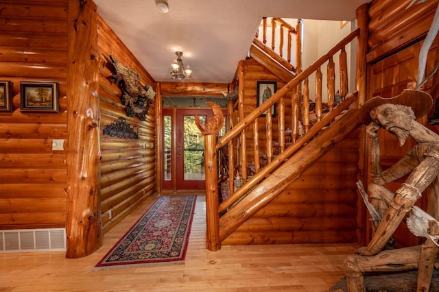 51641 Edgewater Rd, Spring Lake, MN 56680 - foyer entrance featuring log walls, stairs, hardwood / wood-style flooring, and a chandelier