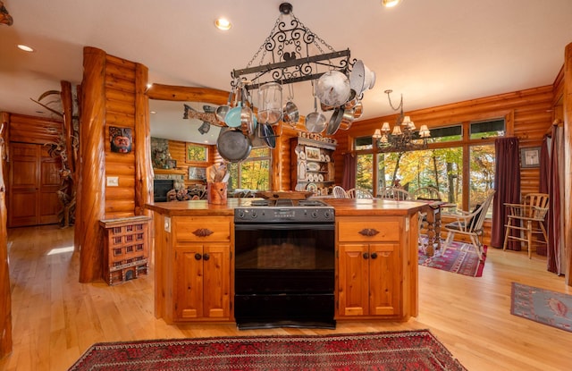 51641 Edgewater Rd, Spring Lake, MN 56680 - kitchen featuring black stove, rustic walls, a chandelier, light wood-style floors, and recessed lighting