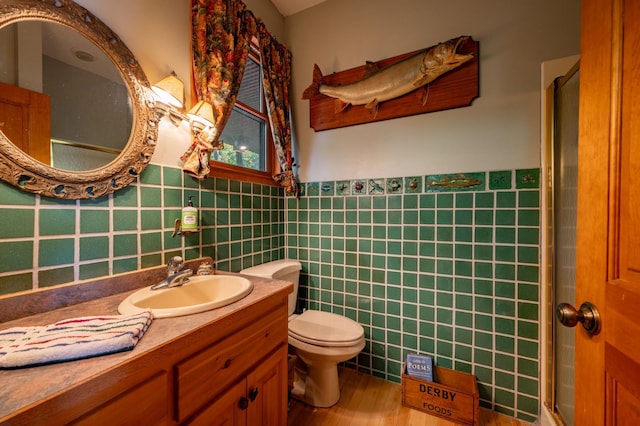 51641 Edgewater Rd, Spring Lake, MN 56680 - full bath with tile walls, a stall shower, a wainscoted wall, vanity, and toilet