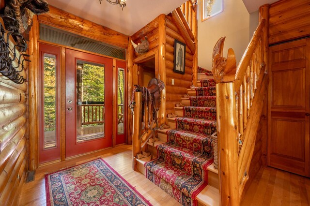 51641 Edgewater Rd, Spring Lake, MN 56680 - entrance foyer featuring rustic walls, stairway, wood-type flooring, and a chandelier