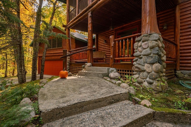 51641 Edgewater Rd, Spring Lake, MN 56680 - property entrance featuring log veneer siding, a porch, and an attached garage