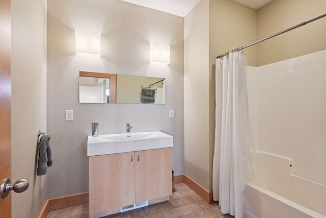 bathroom with baseboards, visible vents, shower / tub combo, and vanity