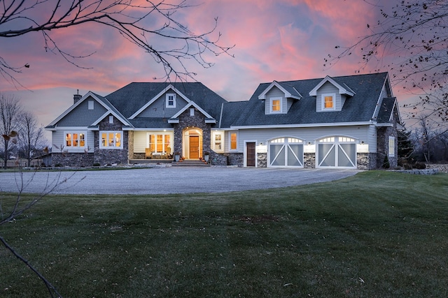 craftsman-style house featuring a chimney, driveway, a front yard, and stone siding