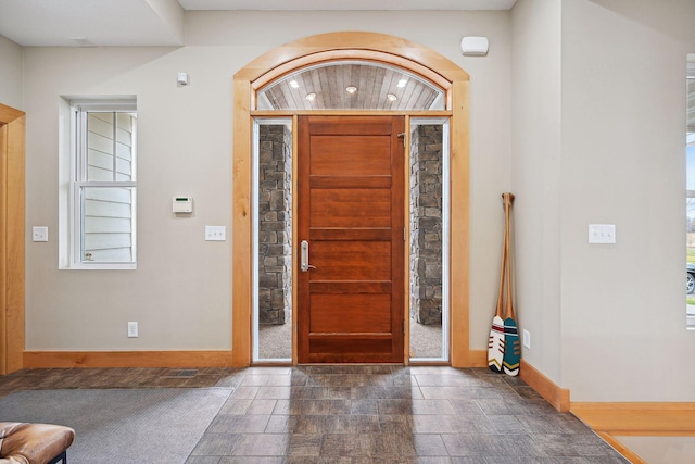 entrance foyer featuring baseboards, recessed lighting, stone finish flooring, and a wealth of natural light