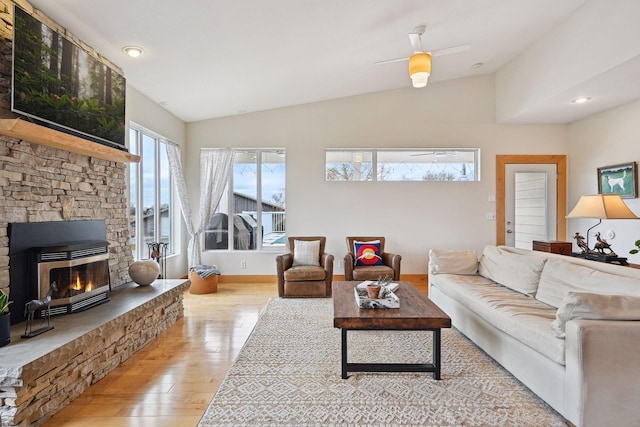 living room featuring vaulted ceiling, hardwood / wood-style flooring, and a fireplace