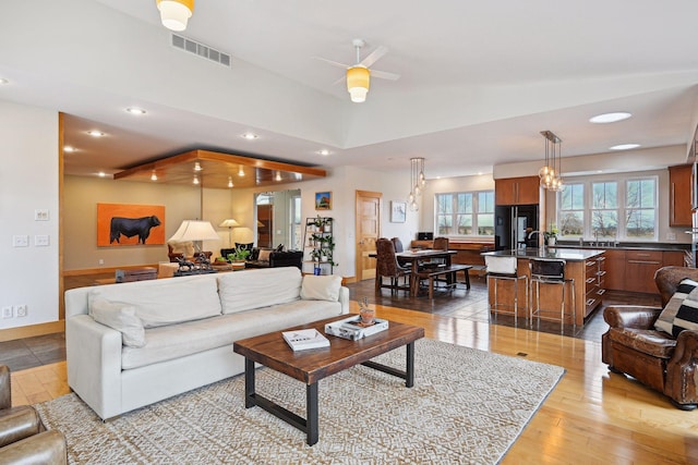 living room featuring visible vents, light wood-style floors, baseboards, recessed lighting, and a ceiling fan