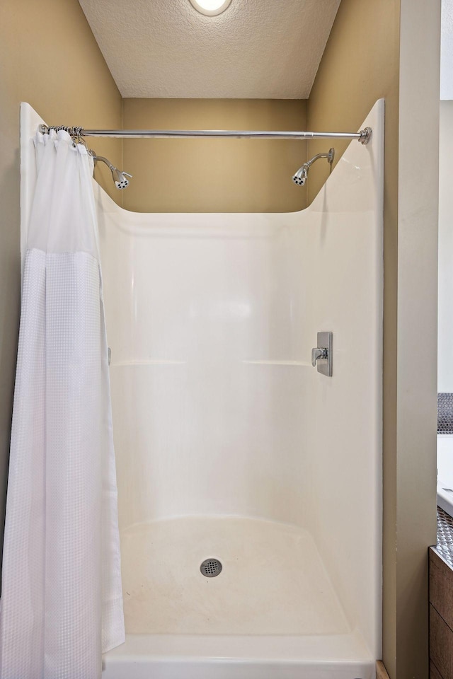 bathroom with a textured ceiling and a shower with shower curtain