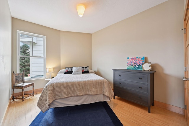 bedroom with light wood-style floors and baseboards