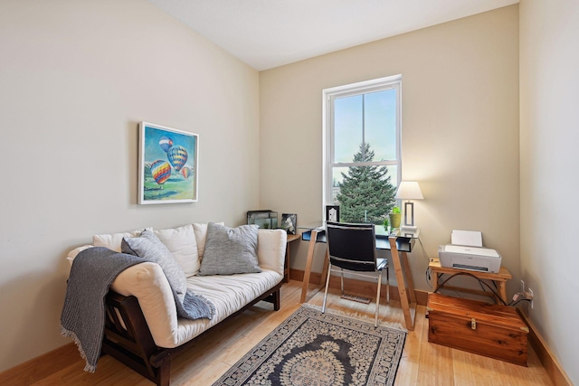 sitting room with baseboards and wood finished floors