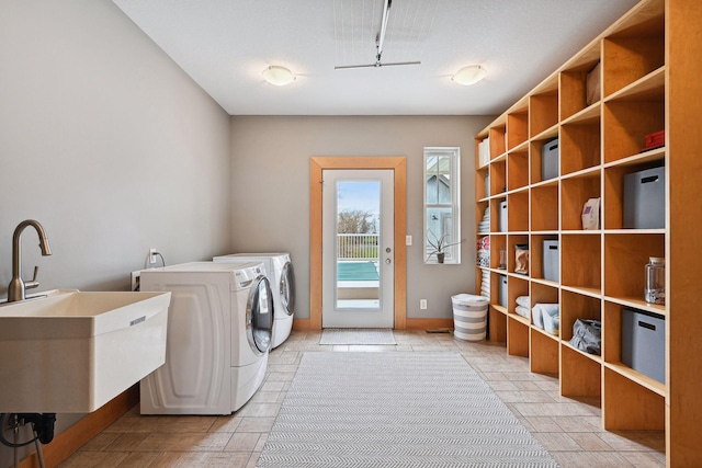 laundry area with a sink, separate washer and dryer, and laundry area