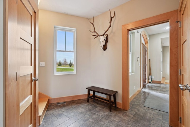 hallway with baseboards and visible vents