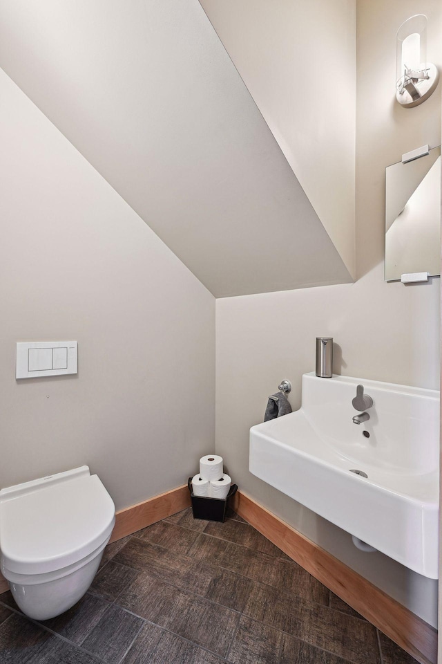 half bath with toilet and baseboards