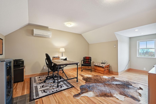 office area with baseboards, a wall mounted AC, wood finished floors, and lofted ceiling