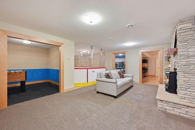 living area featuring baseboards, carpet flooring, a textured ceiling, and visible vents