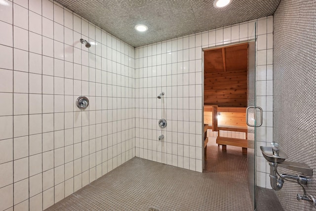 bathroom featuring recessed lighting, tile patterned flooring, and tiled shower